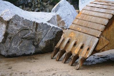 Stein neben Baggerschaufel