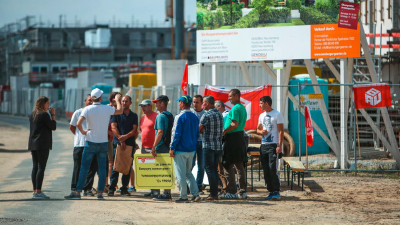 Protestierende Bauarbeiter vor einer Baustelle