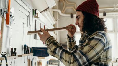 Junger Mann arbeitet in Holzwerkstatt