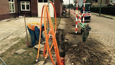 Bauarbeiter verlegt Glasfaserkabel.