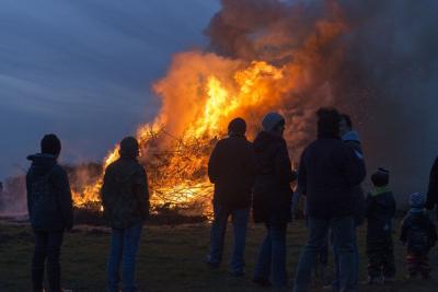 Familien schauen sich ein Feuer an.