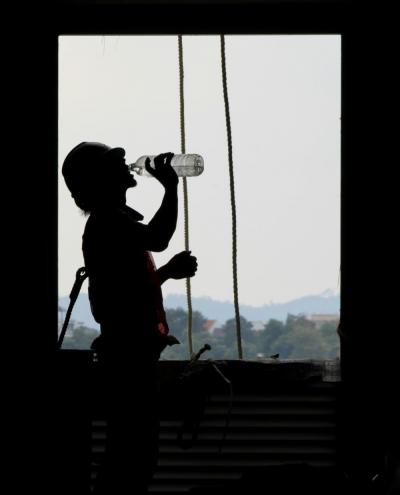 Bauarbeiter trinkt aus Wasserflasche Bauarbeiter trinkt aus Wasserflasche