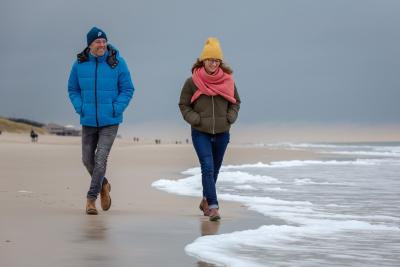 Mann und Frau in Winterkleidung am Strand. Mann und Frau in Winterkleidung am Strand.