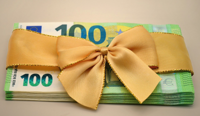 Ein Bündel 100-Euro-Scheine, mit einer Schleife als Geschenk präsentiert Ein Bündel 100-Euro-Scheine, mit einer Schleife als Geschenk präsentiert