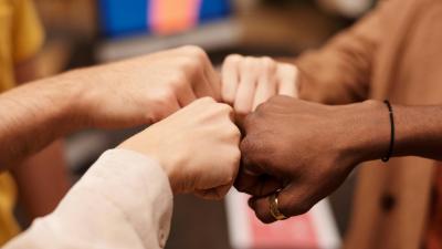 Vier Menschen beim fist bump