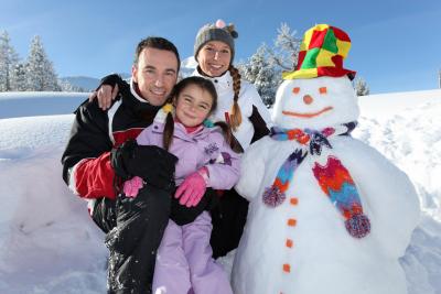 Eine Familie neben einem Schneemann Eine Familie neben einem Schneemann