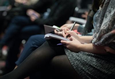 Eine Frau notiert sich etwas in einem Notizbuch.