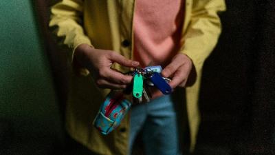 Ein Mensch hält ein Schlüsselbund mit verschiedenen Schildern Ein Mensch hält ein Schlüsselbund mit verschiedenen Schildern