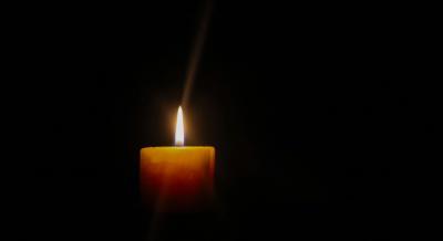 Eine einzelne brennende Kerze im Dunkeln Eine einzelne brennende Kerze im Dunkeln