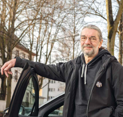 Mann vor geöffneter Autotür