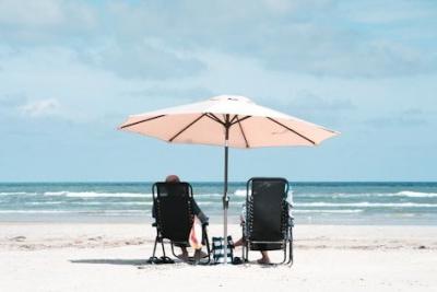 Zwei Menschen auf Liegen am Strand. Zwei Menschen auf Liegen am Strand.