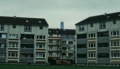Mehrfamilienhäuser unter einem wolkenverhangenen grauen Himmel Mehrfamilienhäuser unter einem wolkenverhangenen grauen Himmel