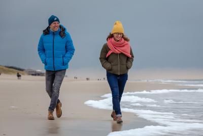 Mann und Frau in Winterkleidung am Strand in Sylt Mann und Frau in Winterkleidung am Strand in Sylt